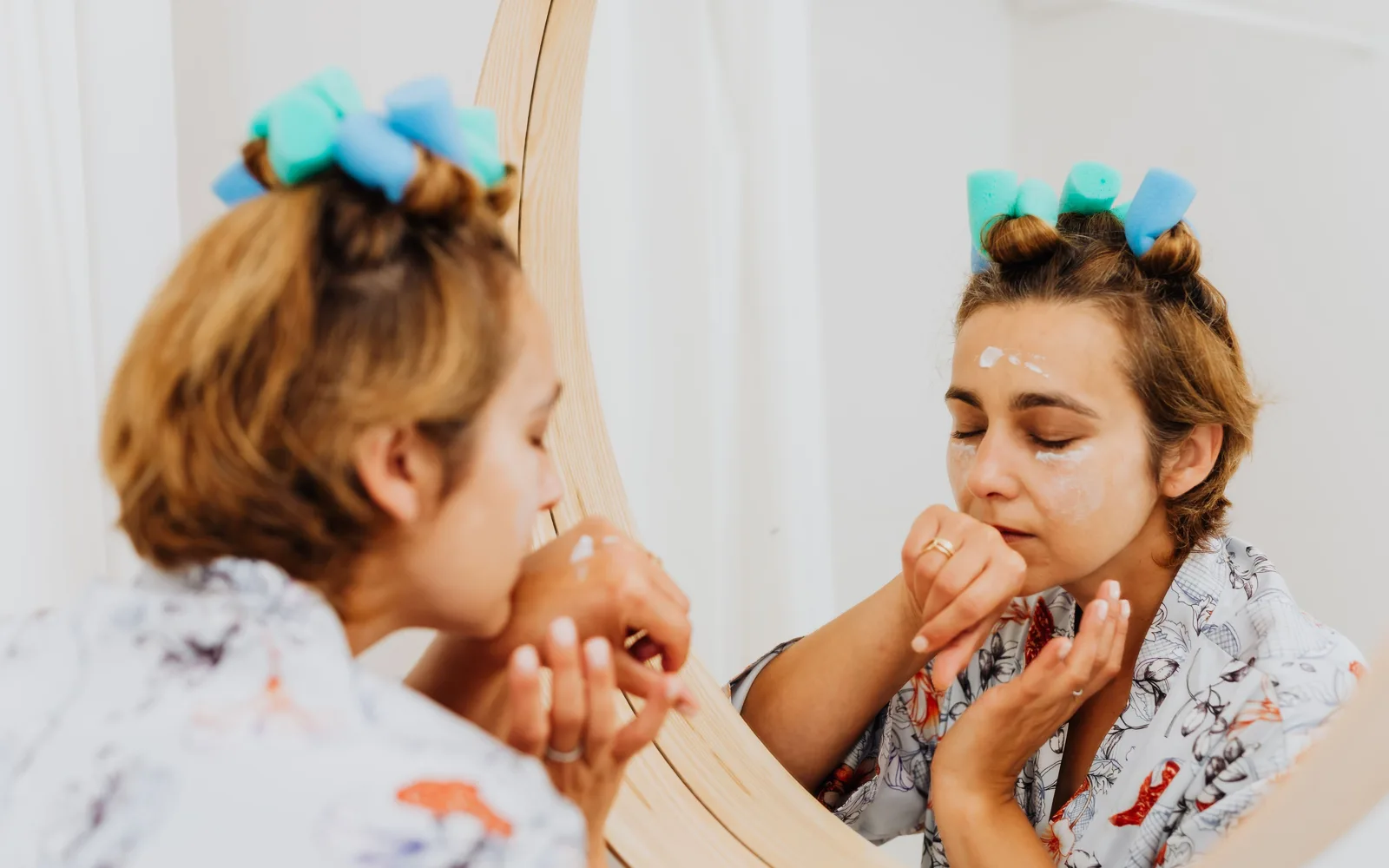 Geste de soin du visage devant un miroir